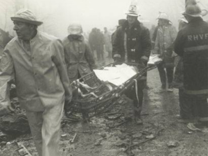 Black and white photo showing Members carring a gurney
