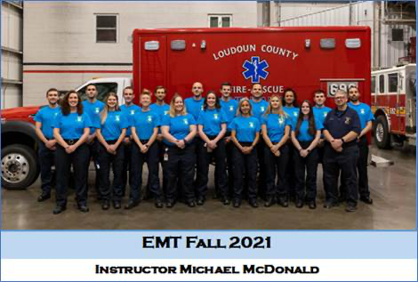 group of graduates in front of ambulance
